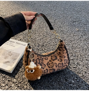 Detail of leopard print crescent bag with leather chain strap and plush charm