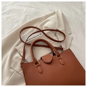 Detailed view of the brown lychee pattern leather tote with golden hardware accents