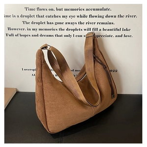 Detail view of large brown suede tote bag with wide nylon strap and side knot detail