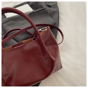 Vue de dessus du sac cabas en cuir verni bordeaux avec bandoulière et boucles