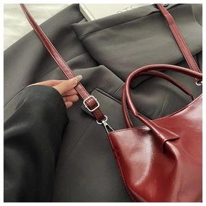 Détail macro du sac cabas en cuir PU bordeaux avec boucle argentée et bandoulière