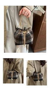 Macro detail of retro plaid bucket bag featuring gold chain drawstring and pearl accents