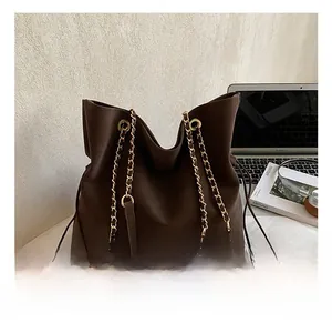 Detail of dark coffee tote bag with metal chain strap and drawstring closure design