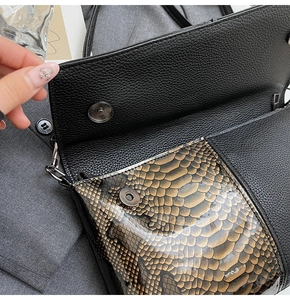 Detail der schwarzen Lederhandtasche mit brauner Schlangenhaut-Klappe und Magnetverschluss