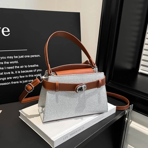 Silver glitter crossbody bag with brown leather handles and adjustable shoulder strap