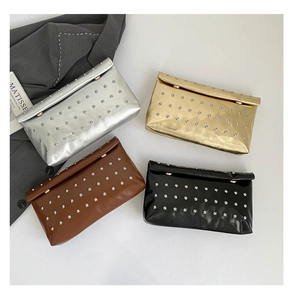 Flat lay of studded clutch bags in silver, gold, black, and brown with metallic finish