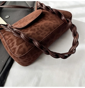 Detail of leopard print suede shoulder bag with braided leather strap and brand logo