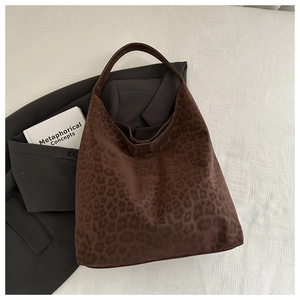 Flat lay of large brown leopard print tote bag with matte texture and shoulder strap