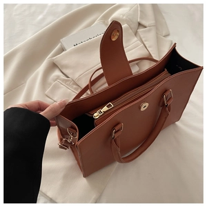 Macro shot of caramel leather tote bag interior with zip pocket and light gold hardware