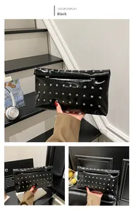 Detail of black glossy clutch bag with silver rivet studs and envelope magnetic closure