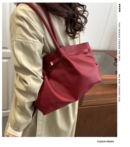 Detail view of burgundy lychee grain leather tote bag with elegant gold hardware buckle