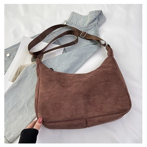 Detail of vintage brown suede crescent shoulder bag with fabric strap and silver buckle