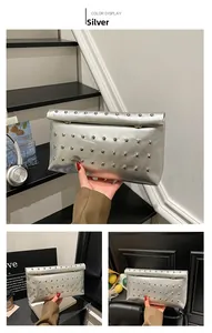 Detail view of silver envelope clutch bag with metal rivet studs and glossy finish