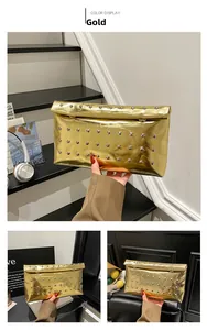 Detailed view of a gold metallic clutch bag featuring silver studs and fold-over design
