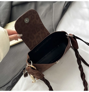 Detail of leopard print handbag with magnetic closure and wide woven strap