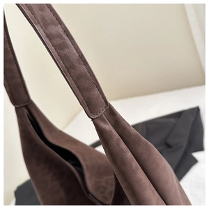 Detail of premium brown suede tote bag featuring subtle leopard print and wide shoulder strap