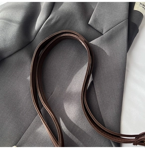 Close-up of deep brown litchi pattern leather shoulder strap with neat hand stitching