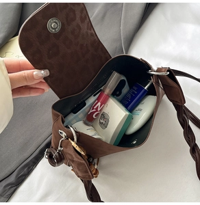 Detail view showing large storage capacity of brown suede crossbody bag with daily items