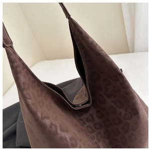 Detail of dark brown leopard print hobo bag showing faux suede texture and metal snap button