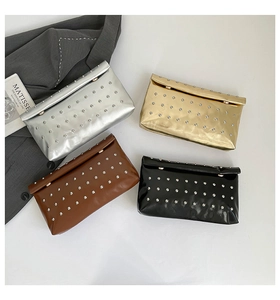 Vue à plat de petites pochettes enveloppes en argent, or, marron et noir avec des clous