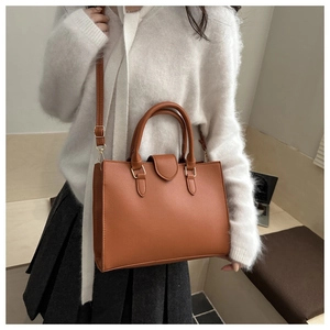 Detail einer braunen Leder-Tote-Bag mit Narbenstruktur und verstellbarem Schultergurt