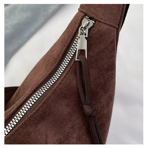 Detailed close-up of metal zipper and woven cord puller on frosted leather tote bag