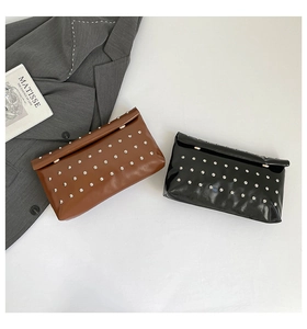 Flat lay of brown and black leather envelope clutch bags with silver rivet studs