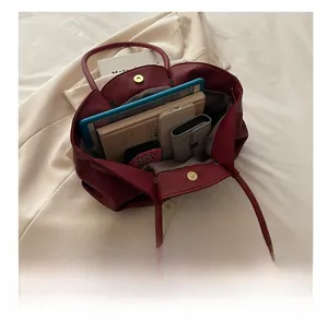 Détail du sac cabas bordeaux en cuir grainé montrant sa grande capacité de rangement