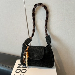 Black leopard print shoulder bag with woven strap and decorative beaded charm detail