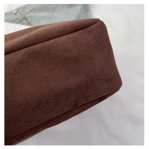 Detailed close-up of dark brown suede tote bag with clean stitching and matte texture