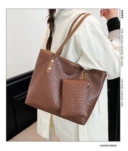 Dettaglio della borsa tote in pelle intrecciata marrone con pochette e rivetti metallici