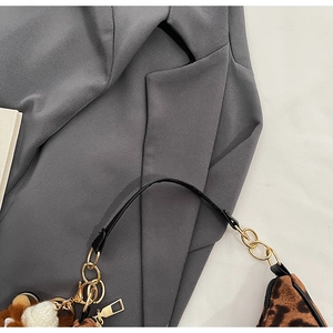 Detail of leopard print handbag with golden chain rings and black shoulder strap
