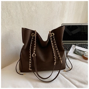Dark brown suede bucket bag featuring golden chain straps and drawstring closure details
