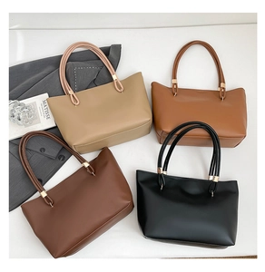 Flat lay showing four minimalist tote bags in beige, brown and black leather finishes