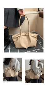 Detail of beige tote bag with pebbled leather texture and elegant gold metal buckle
