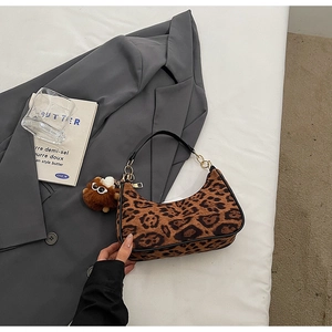 Detailed leopard print hobo bag with gold chain strap and plush bear accessory