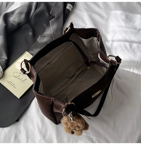 Detailed interior of the dark brown leather tote bag with large capacity and zipped pockets