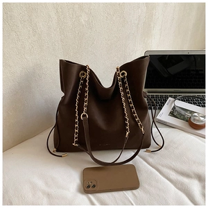 Detail of dark brown matte leather tote bag with gold chain strap and matching phone case