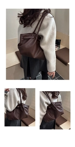 Detailed macro view of dark brown pebbled leather texture on a spacious commuter tote bag