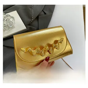 Gros plan détaillé de la pochette dorée texture Saffiano avec boucle en métal ondulé