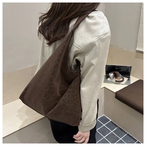 Détail du grand sac cabas imprimé léopard avec texture lisse et design hobo porté à l'épaule
