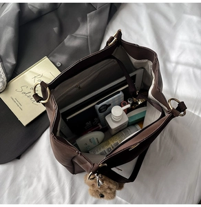 Interior view showing the large capacity and functional compartments of this brown tote bag