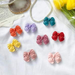 Flat lay of colorful matte bow phone sockets in Morandi colors on a white fabric background
