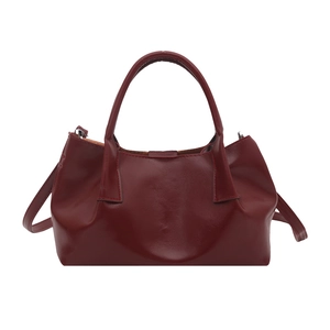 Deep red vintage tote bag in leather texture with top handles and adjustable strap