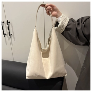 Détail d'un sac cabas crème minimaliste avec finition mate et large bandoulière