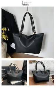 Detail of black oil-wax leather tote bag featuring gold hardware and flexible straps