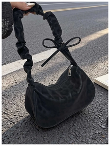 Détail d'un sac bandoulière léopard noir avec bandoulière froncée et nœud décoratif