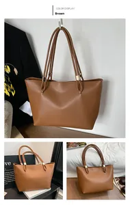 Detail view of large brown oil wax leather tote bag with gold metallic buckle accents