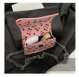 Internal view of pink cherry print mini bag showing capacity for lipstick and earbuds