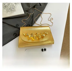 Détail du mini sac à main doré texturé avec décoration métallique en forme de vague